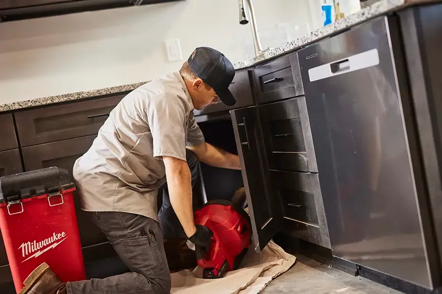 Pine Creek plumber working under kitchen sink